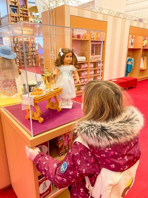 A young girl looks at a doll in a case at the American Girl Place.