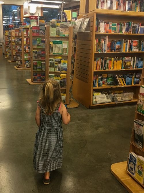 A young girl walks through the aisles of books at Powell's Books, one of the best things to do in Portland with kids.