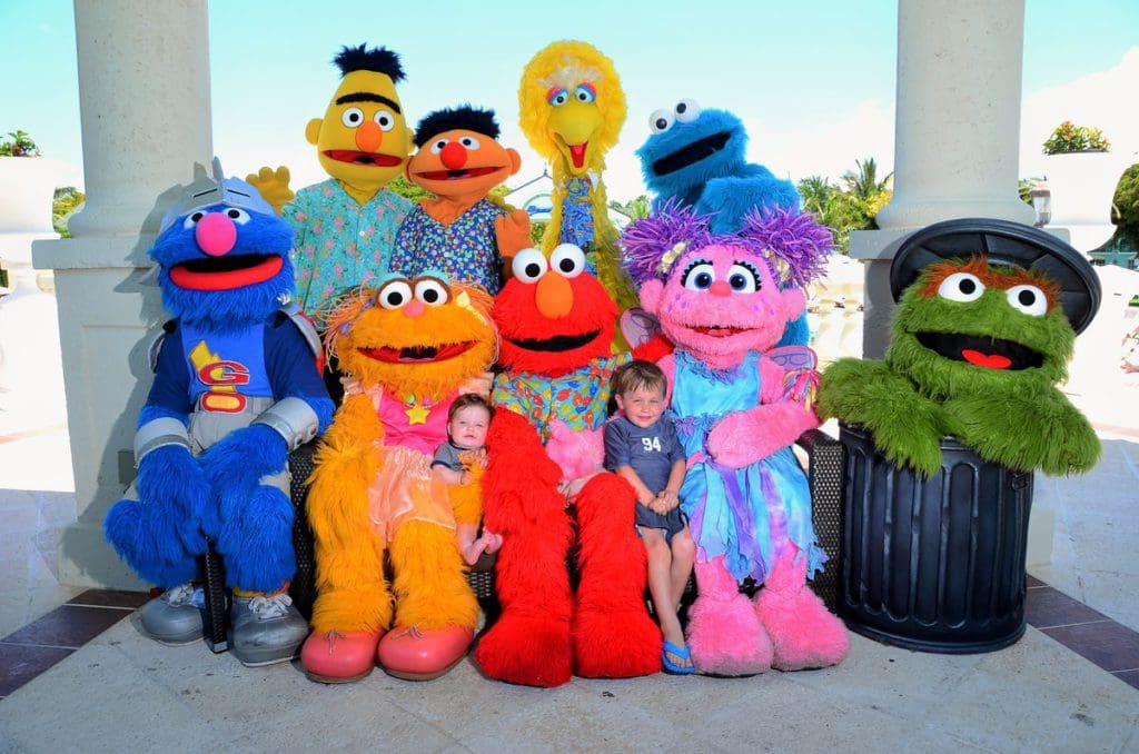 Two boys cuddle with Sesame Street mascots at a Beaches resort.