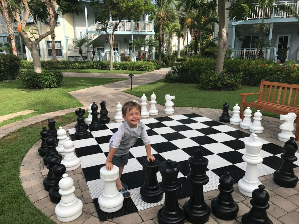 A young boy plays a large lawn chess game at a Beaches resort in Turks and Caicos.
