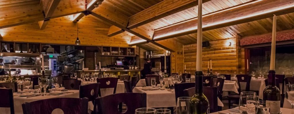 The indoor dining room at Cloud Nine Alpine Bistro, featuring a cabin-style interior and well furnished tables.