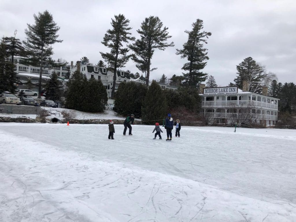 Several kids skate on an outdoor rink near Lake Placid.