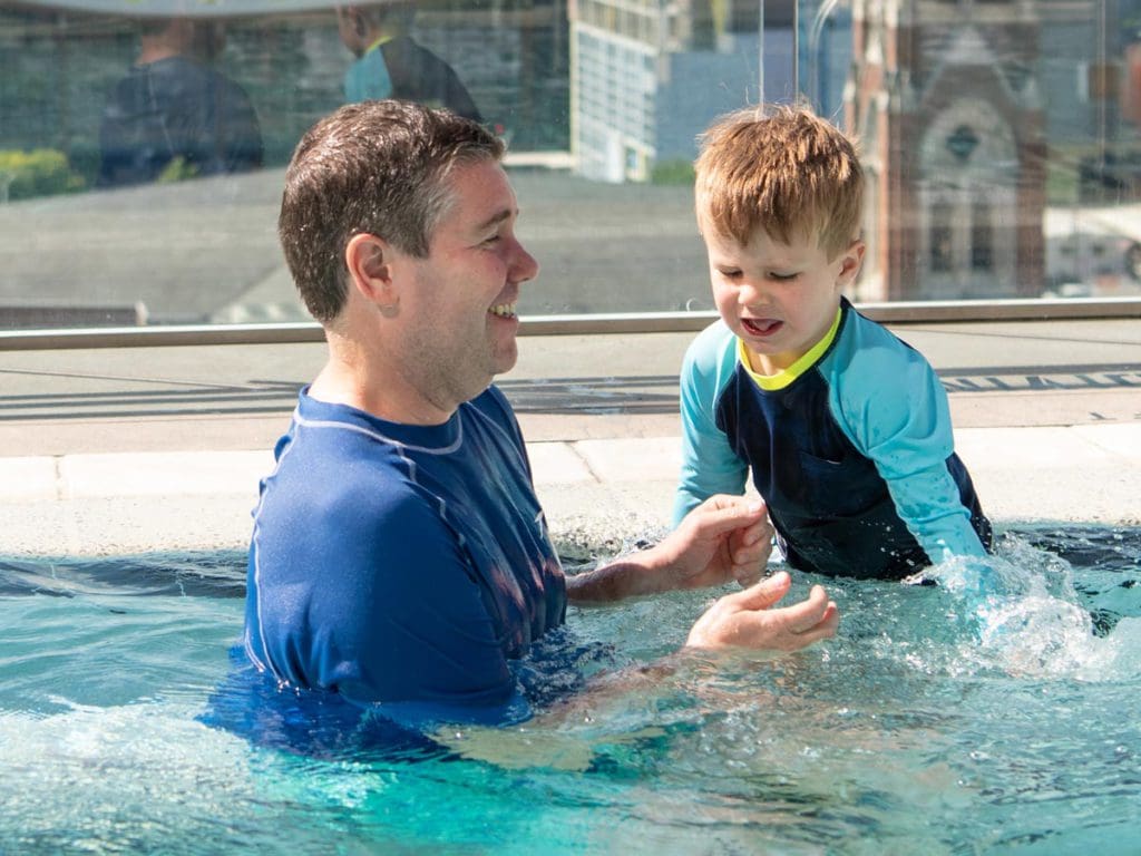 A dad and his young son play in a pool at a hotel in Nashville.