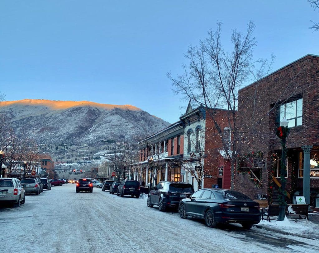 A view of downtown Aspen covered in snow, with mountains in the background. 