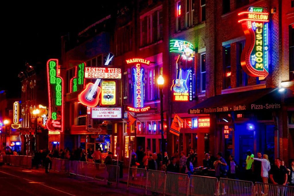 A view of a street in Nashville, featuring rows of neon lights announcing bar and restaurant locations, one of the best Moms’ Getaways or Girls’ Trip Ideas.