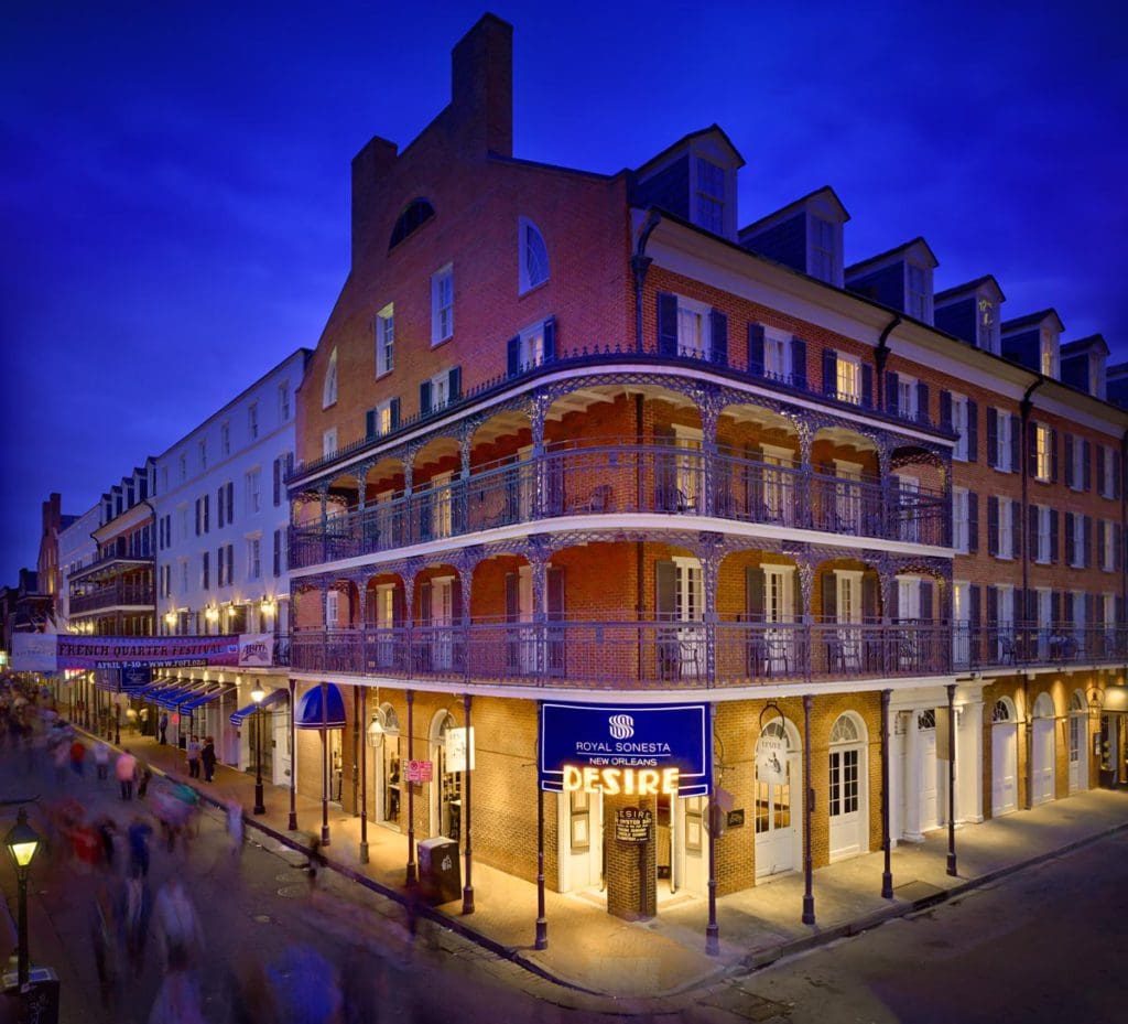 The corner exterior of Royal Sonesta New Orleans, featuring a well-lit entrance at night, one of the best hotels in New Orleans for families.