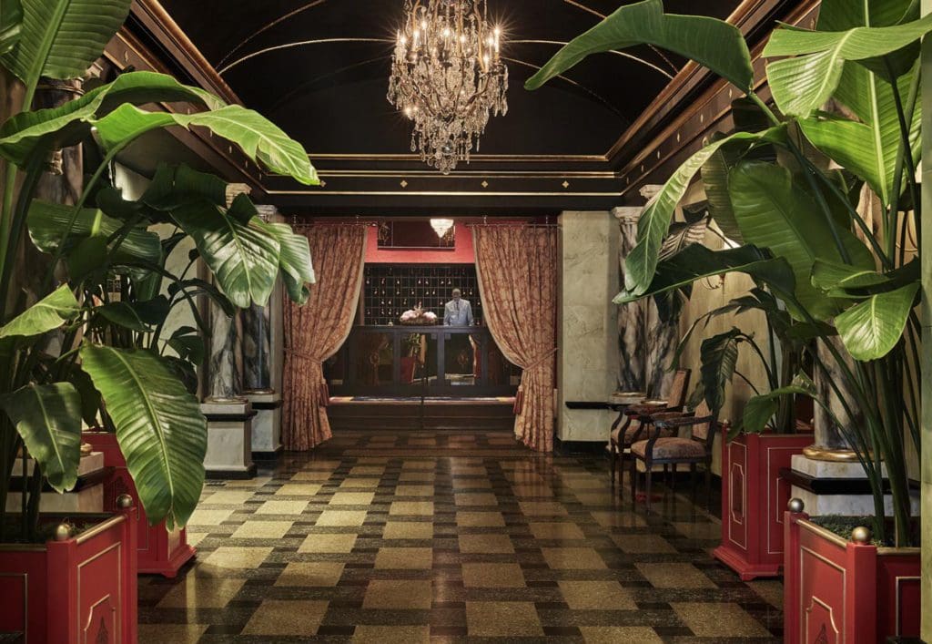 The large entrance and lobby at The Pontchartrain Hotel, featuring dark, rich colors and large plants.