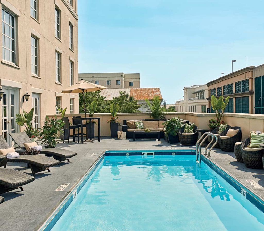 The outdoor pool at The Renaissance Charleston Historic District Hotel, flanked by poolside loungers on both sides, on a sunny day.