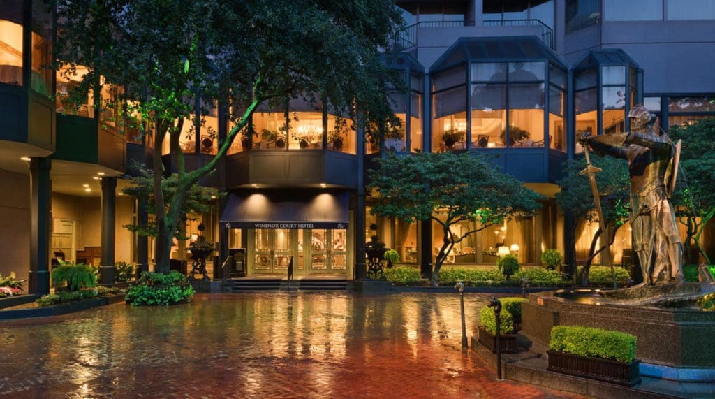 The well-lit exterior entrance to the Windsor Court Hotel at night, one of the best hotels in New Orleans for families.