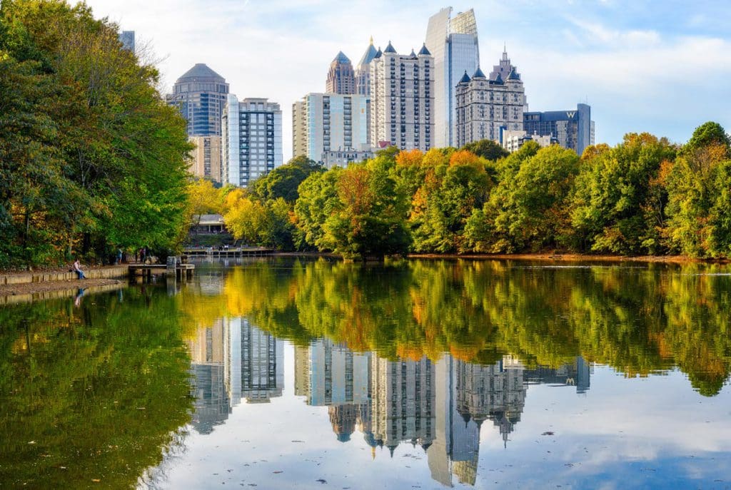 A stunning view of Lake Clara Meer in the fall, with the downtown skyline behind it, at Piedmont Park.