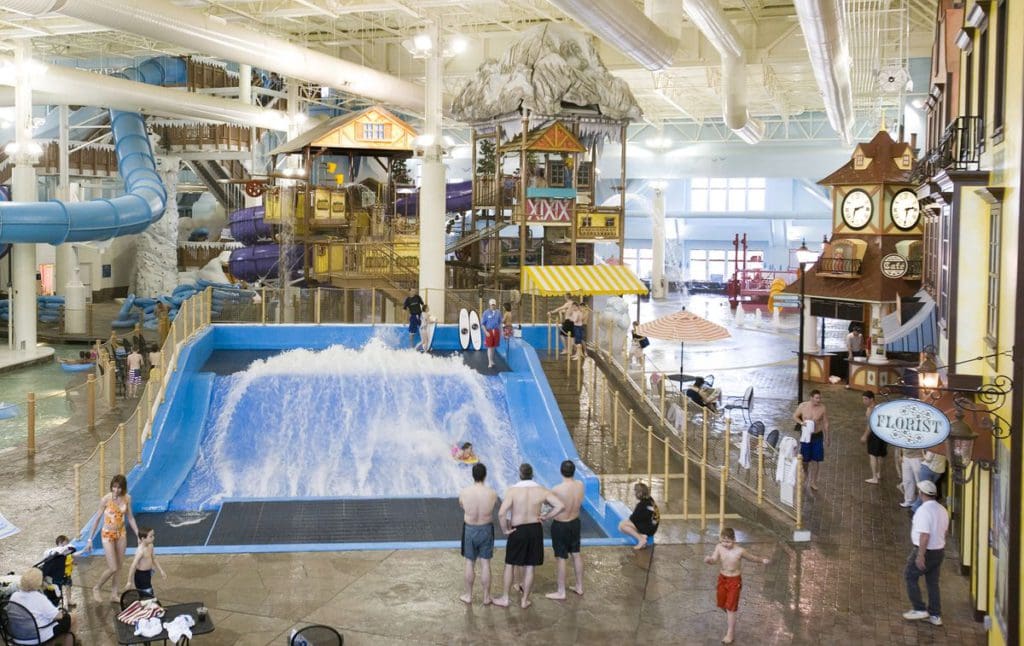 Several people enjoy the amenities of the indoor water park at Boyne Mountain Resort, including a surfing zone and water slides.