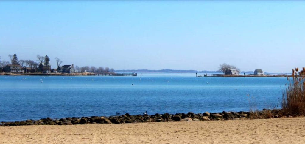 Esker Point Beach, featuring a sandy shoreline and water in the distance.