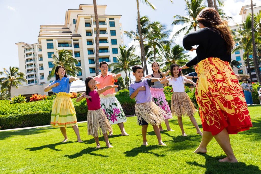 A staff member teaches kids a traditional Hawaiian dance at Marriott's Ko Olina Beach Club, one of the best resorts for families in O'ahu.