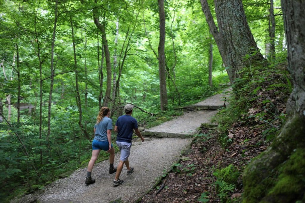 Two hikers walk along a paved path at Mammoth Cave.