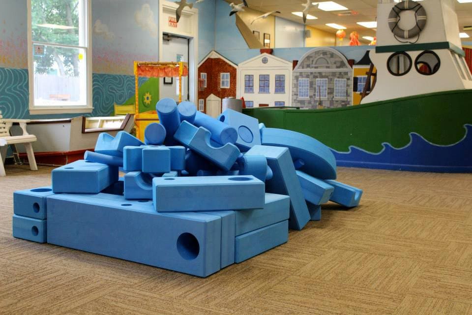 Inside Niantic Children's Museum, featuring large rubber bricks for kids to jump and play on.