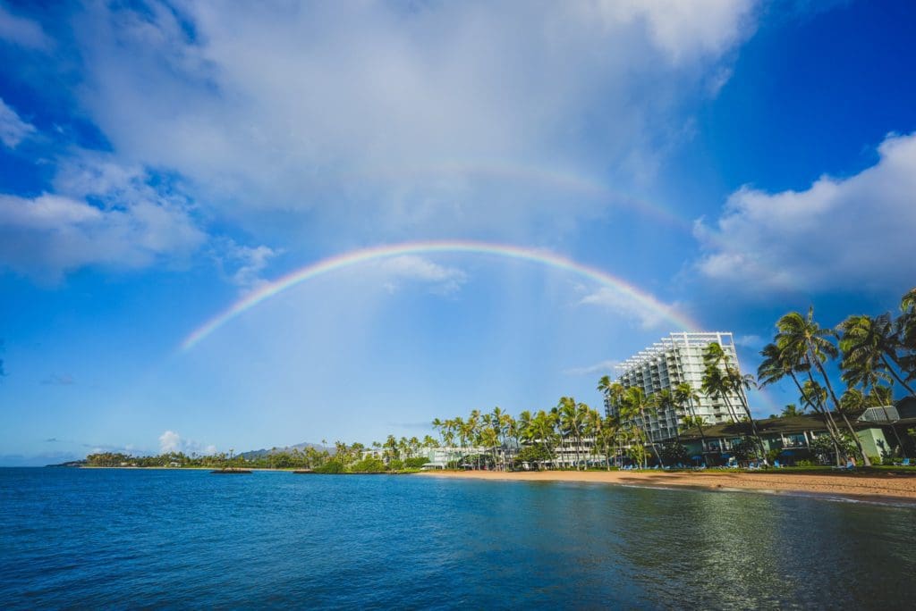 A rainbow stretches over The Kahala Hotel & Resort and the nearby beachfront, one of the best resorts for families in O'ahu.