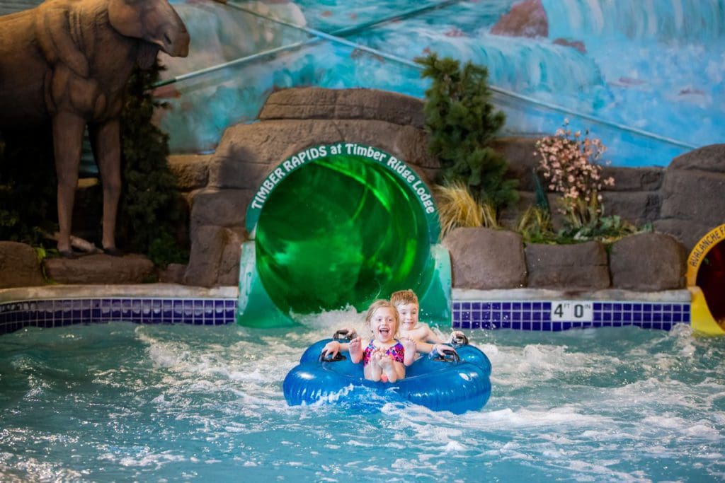 Two kids shoot down an indoor water slide at Timber Ridge Lodge & Waterpark.
