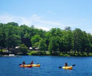 A family spends the afternoon kayaking in the lake at Woodloch Resort.