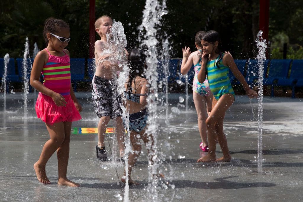 Several kids run and splash through the splash zone at Zoo Atlanta.
