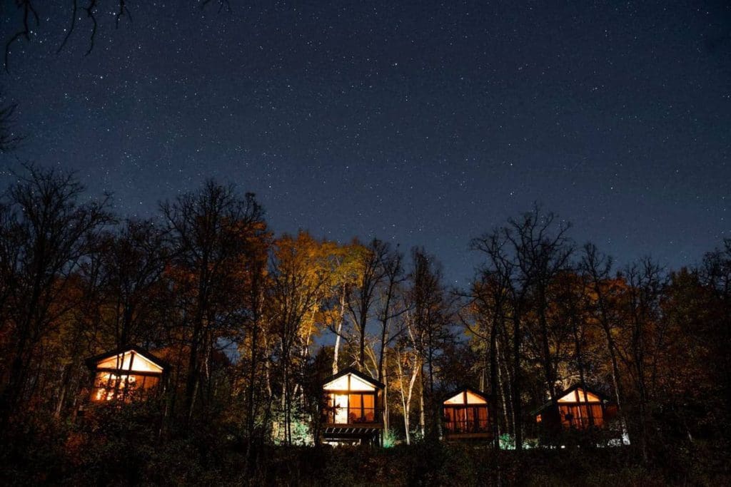 Four cabins sit amongst the trees, with an array of stunning stars overhead, at Cuyuna Cove.