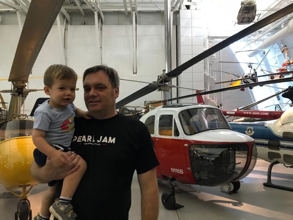 A man holds his young son in front of an airplane at Smithsonian National Air & Space Museum and Udvar-Hazy Center.