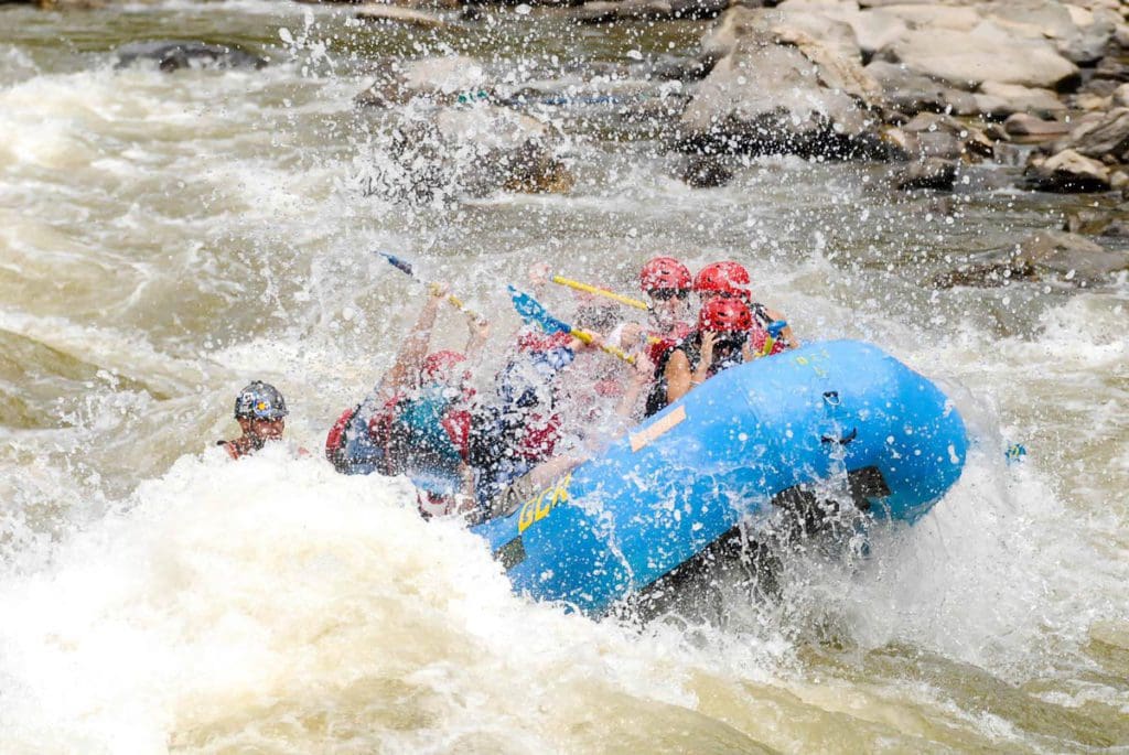 Several people raft down a river in Colorado with Glenwood Canyon Rafting, a great activity on our one-week Colorado itinerary for families.