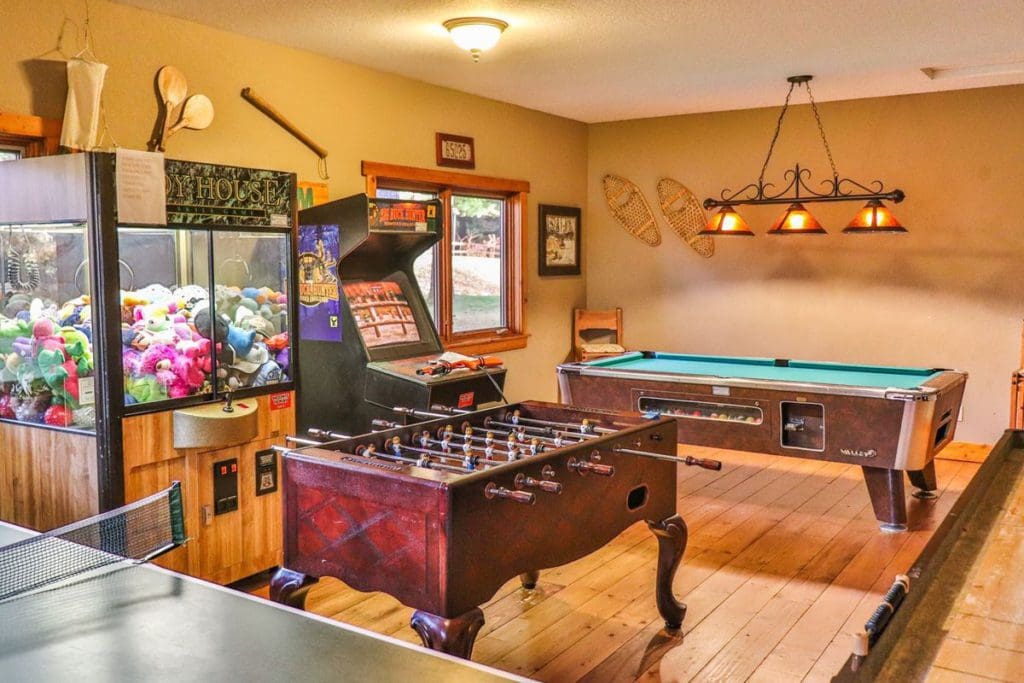 Inside the game room at Good Ol’ Days Family Resort, featuring a claw machine, pool table, and foosball table.
