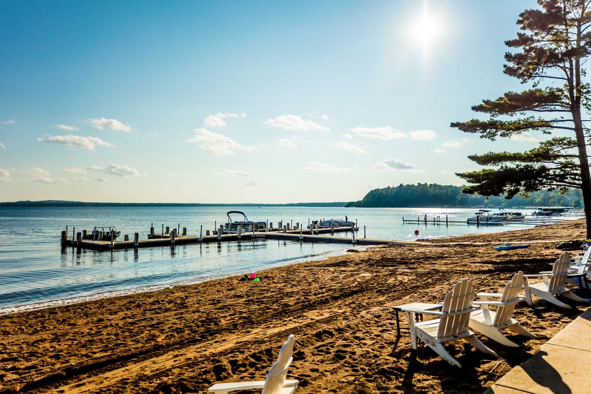 A stunning lake shoreline in Minnesota, featuring large docks and a sandy beach at Grandview Lodge, one of the best all-inclusive hotels in the United States for families.