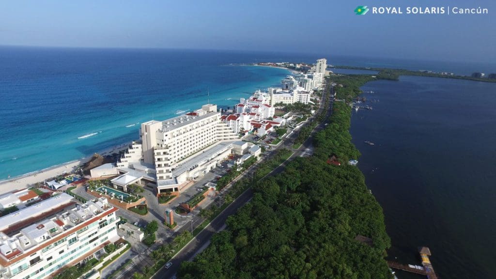 An aerial view of Royal Solaris Cancun, featuring its oceanfront location, pristine buildings, and surrounding ocean.