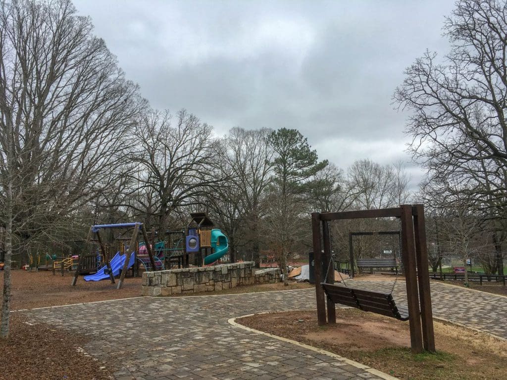 Chastain Park Playground in Atlanta, featuring ample seating for parents, as well as wide, paved walkways and a large playground area for kids.