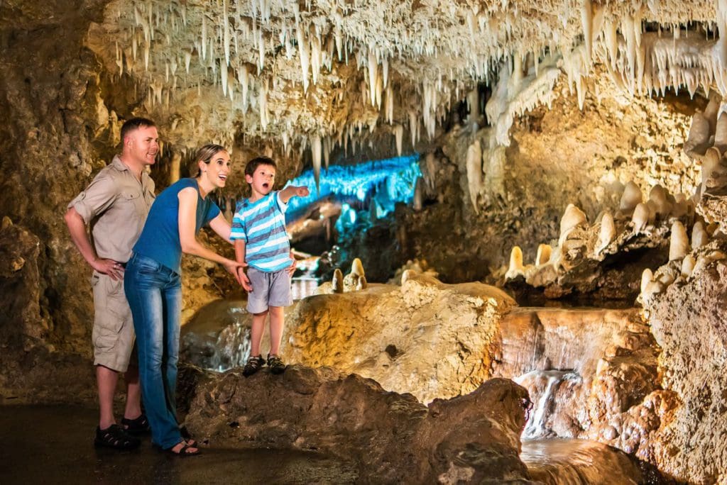 Two parents and their young child explore Harrison's Cave.