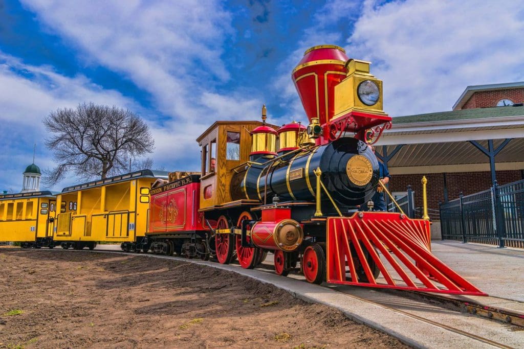 A colorful train zooms along a track at Bay Beach Amusement Park, one of the best places to visit in Wisconsin for families.