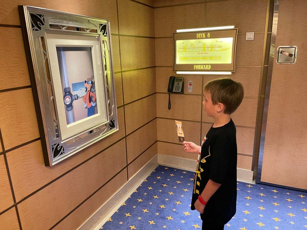 A young boy watched an interactive display with Goofy, while sailing aboard a Disney cruise ship.
