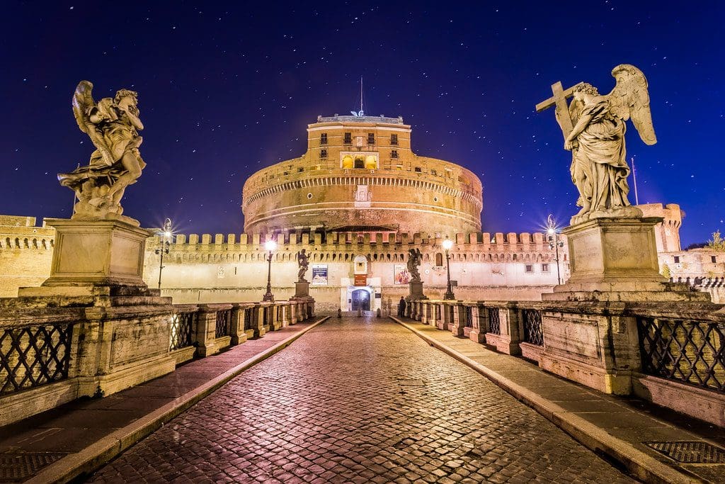 The Castel Sant'Angelo lit up at night, one of the best museums in Rome with kids.