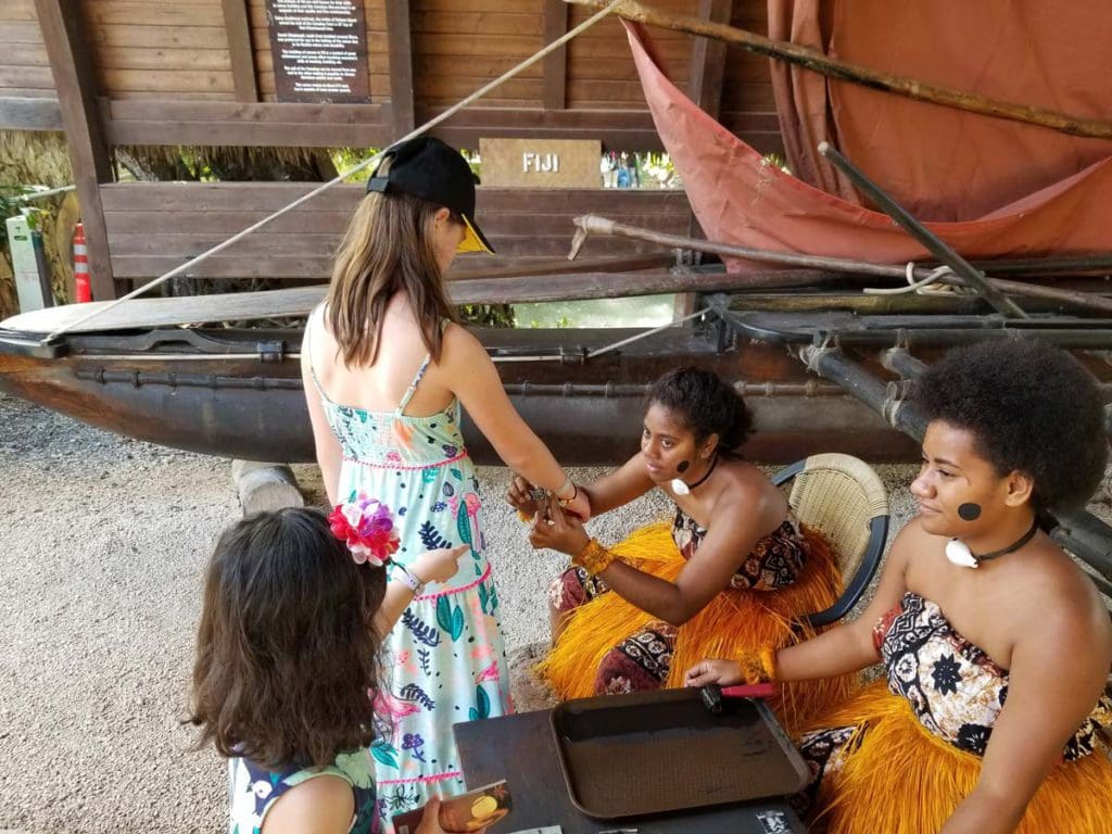 A young girl gets her arm painted during an interactive lesson at the Polynesian Culture Center.