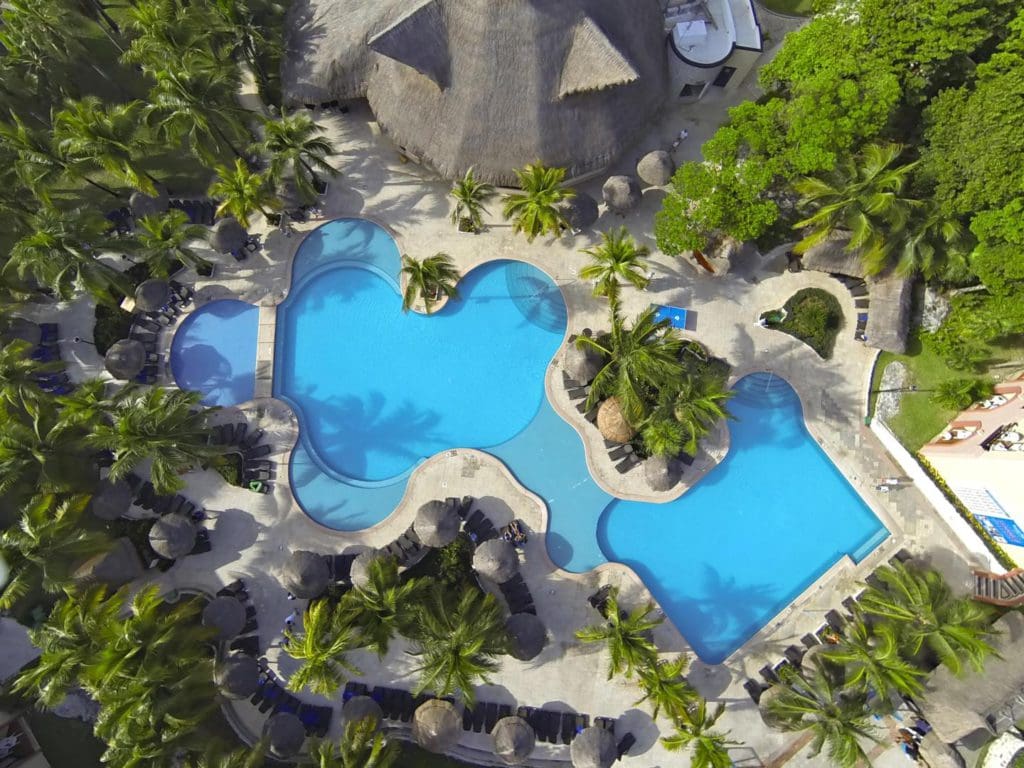 An aerial view of the pool and surrounding pool deck at Sandos Playacar Beach Resort, one of the best all-inclusive resorts Playa del Carmen for families.
