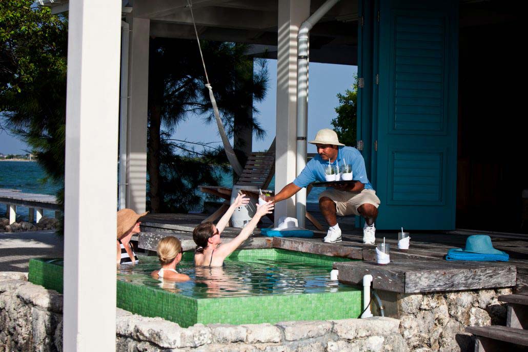 Kids swim in a small pool, while a staff member serves them drinks at Cayo Espanto Island Resort.