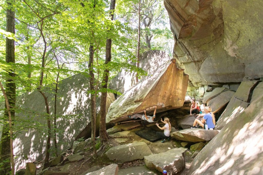 Several people boulder along a large rock outcropping at Jackson Falls in Shawnee National Forest.