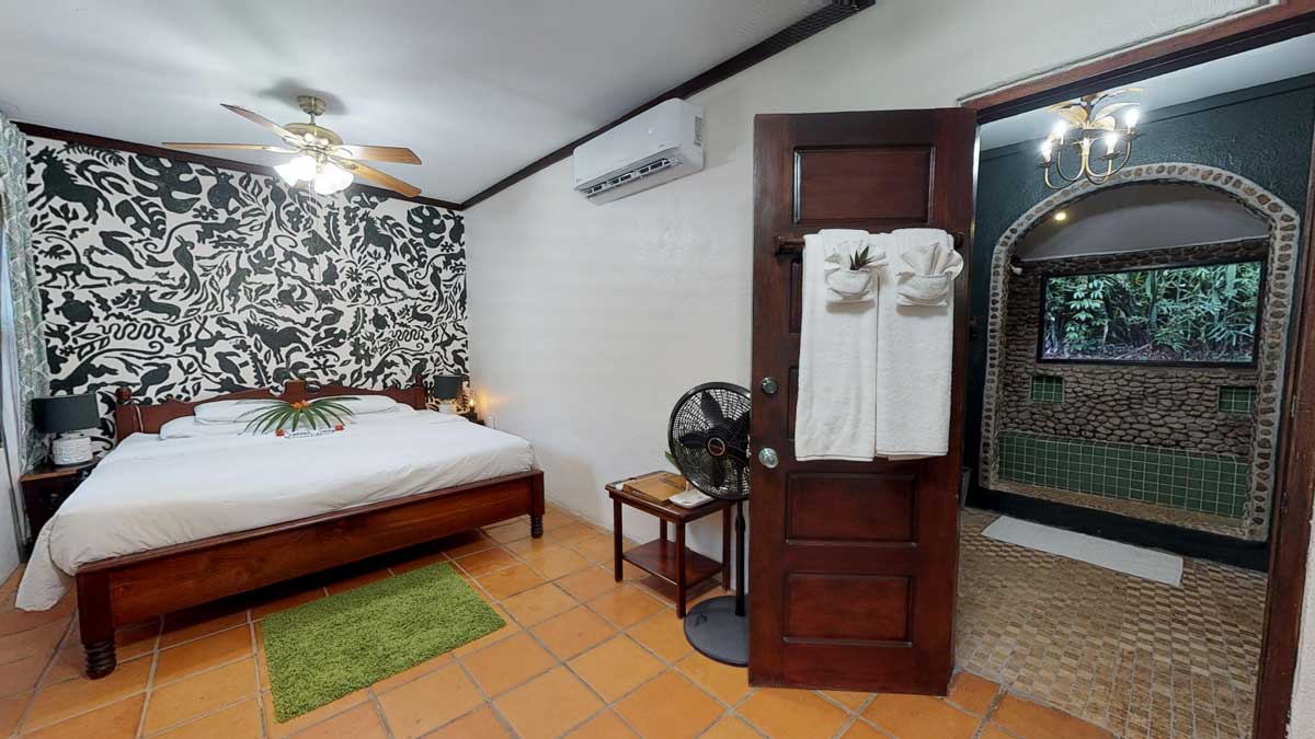 Inside the large bedroom of the villas at Sweet Songs Jungle Lodge, a Muy’Ono Resort, featuring a large bed.