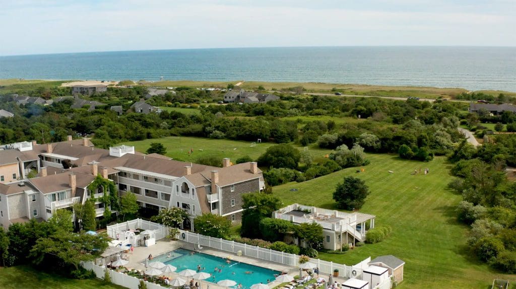 Aerial view of the outdoor pool and surrounding trees at The Nantucket Hotel & Resort, one of the best luxury hotels in the U.S for families.