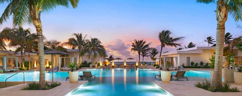 The charming pool and surrounding pool deck at Alaia Belize, Autograph Collection at dusk, one of the best Belize resorts for a family vacation! 