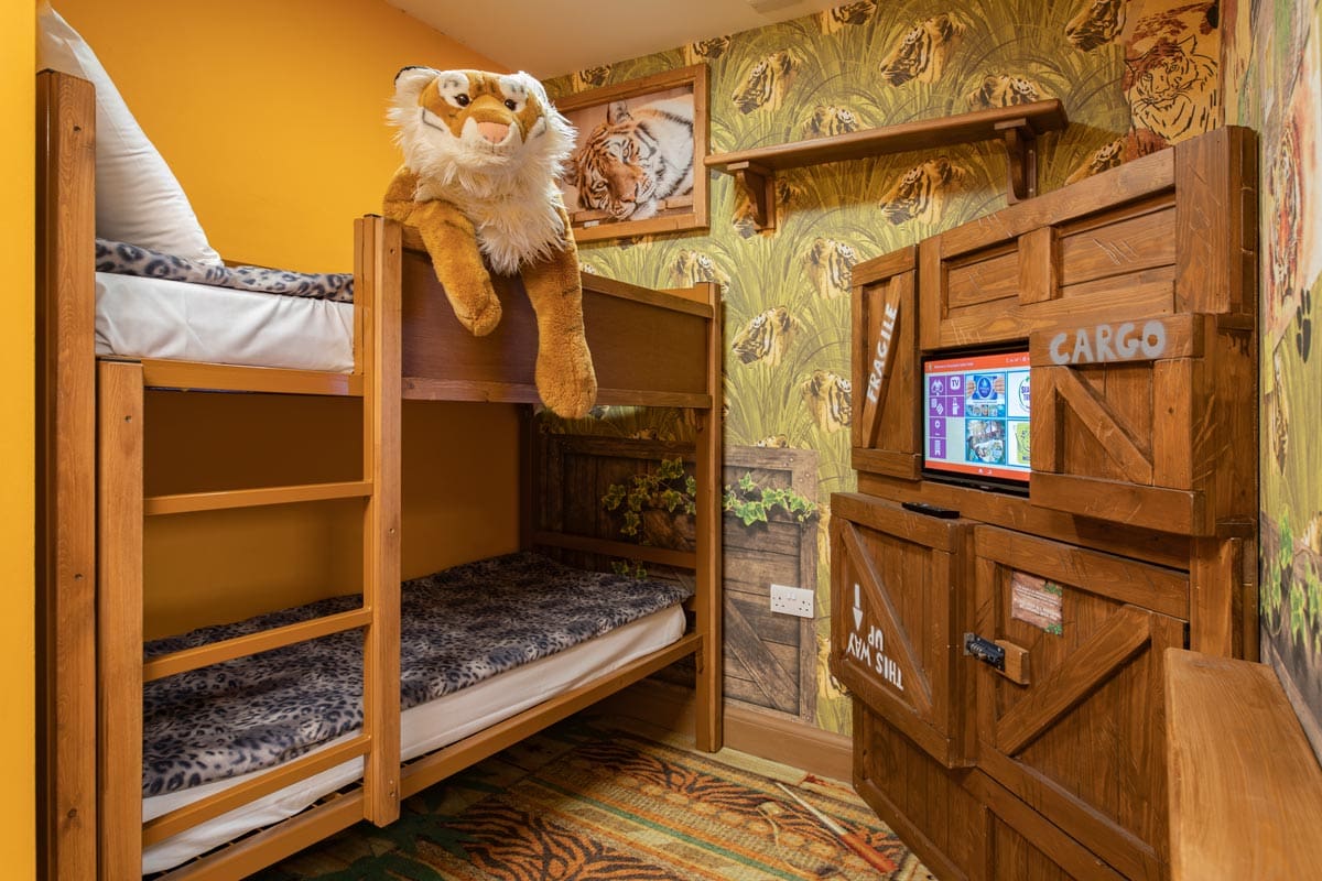 A plush tiger sits atop a bunk bed in the safari-themed room at Chessington Safari Hotel.