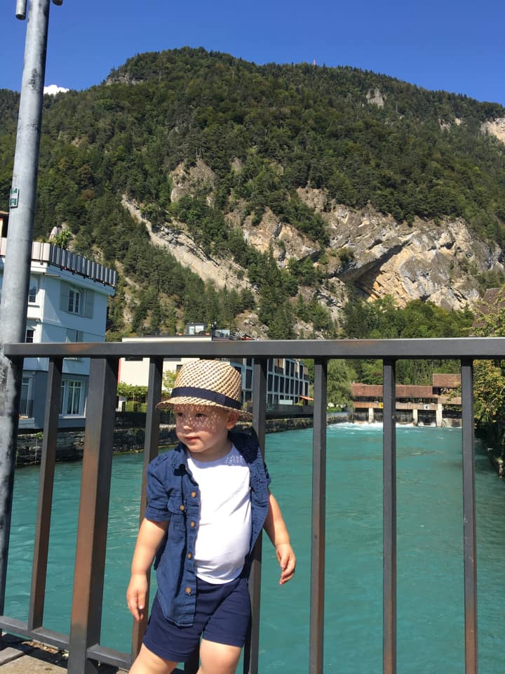 A young boy stands on a bridge near Lake Geneva in Interlaken.