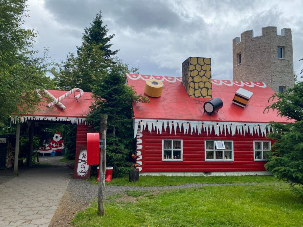 A bright red house decorated like a gingerbread house called Jólahúsið, aka the Christmas House, a fun stop on this Iceland itinerary for families.