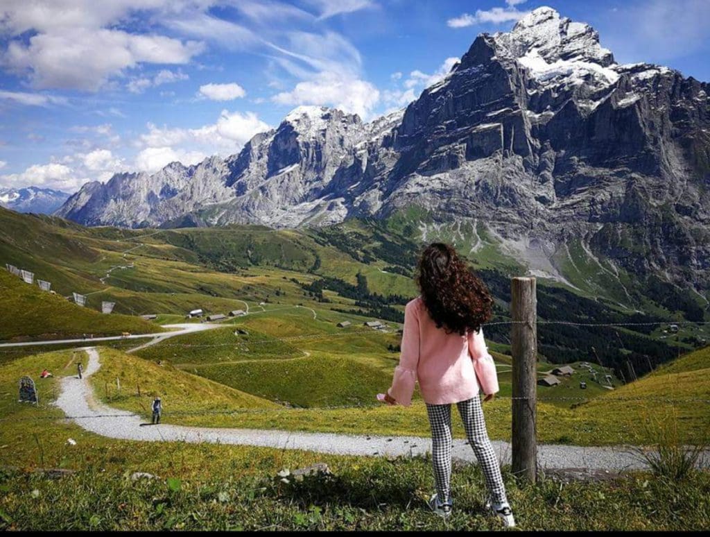A young girl looks out toward a mountain while embarking on the First Cliff Walk near Tissot, a fun stop on any Switzerland itinerary with kids.