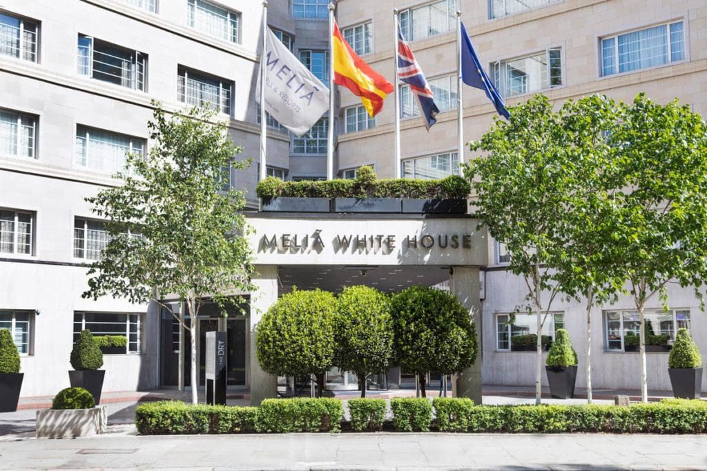 The exterior entrance to Melia White House, with flags over the entrance way.