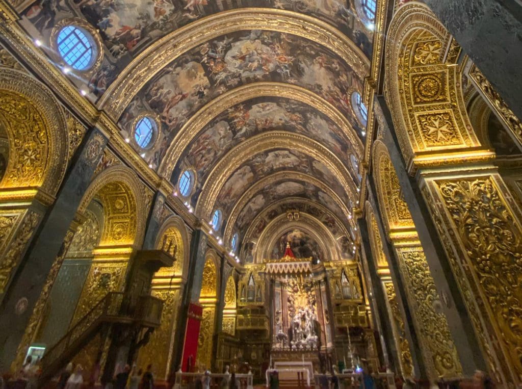 The inside of St. John’s Cathedral in Valletta, ornately decorated in hues of gold - visiting this church is this is one of our best tips for visiting Malta with kids.