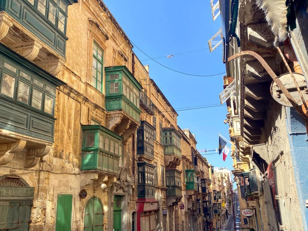 Looking down a historic street in Malta on a sunny day, download the Bolt App will help you navigate streets by hired car, this is one of our best tips for visiting Malta with kids.