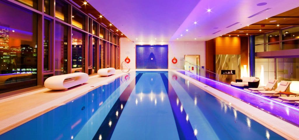 The indoor pool, with surrounding pool deck and loungers, at The Ritz-Carlton, Montreal.