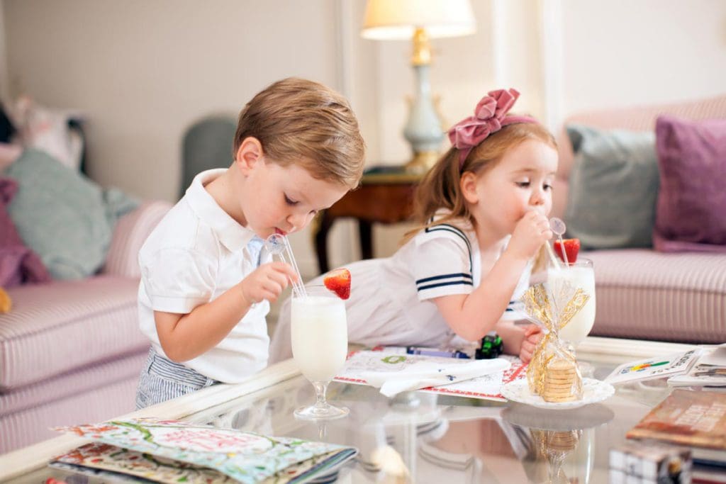 Two kids enjoy special milkshakes in their room at The Ritz London.
